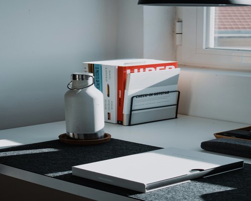 Organized modern desk with a water bottle and notebook