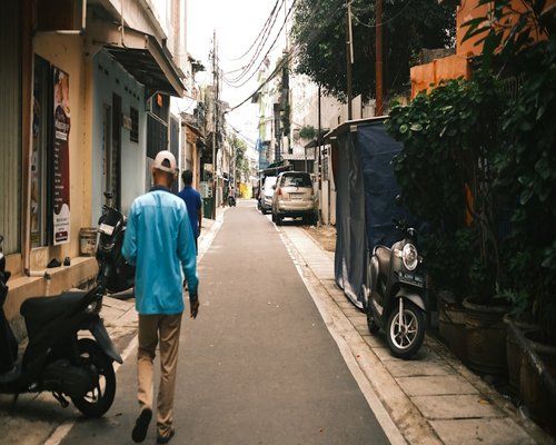 Person walking comfortably on a sidewalk in Indonesia